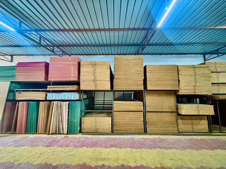 Retail stockroom with light MDF and particle-board stacks beside Sansui plywood