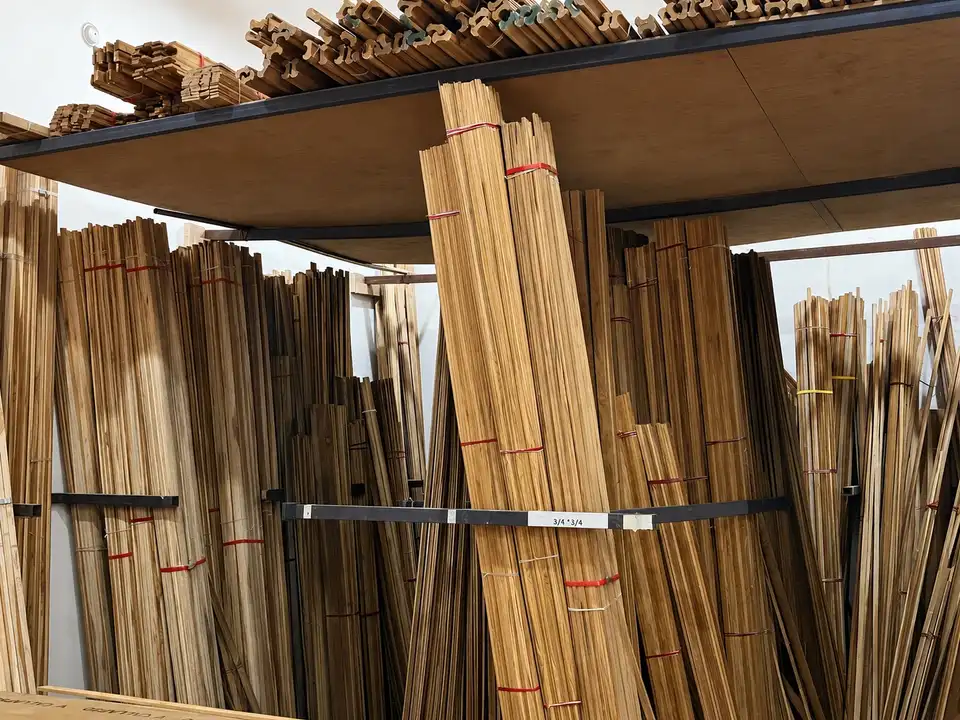 Bundles of thin timber mouldings and strips stored against metal racks